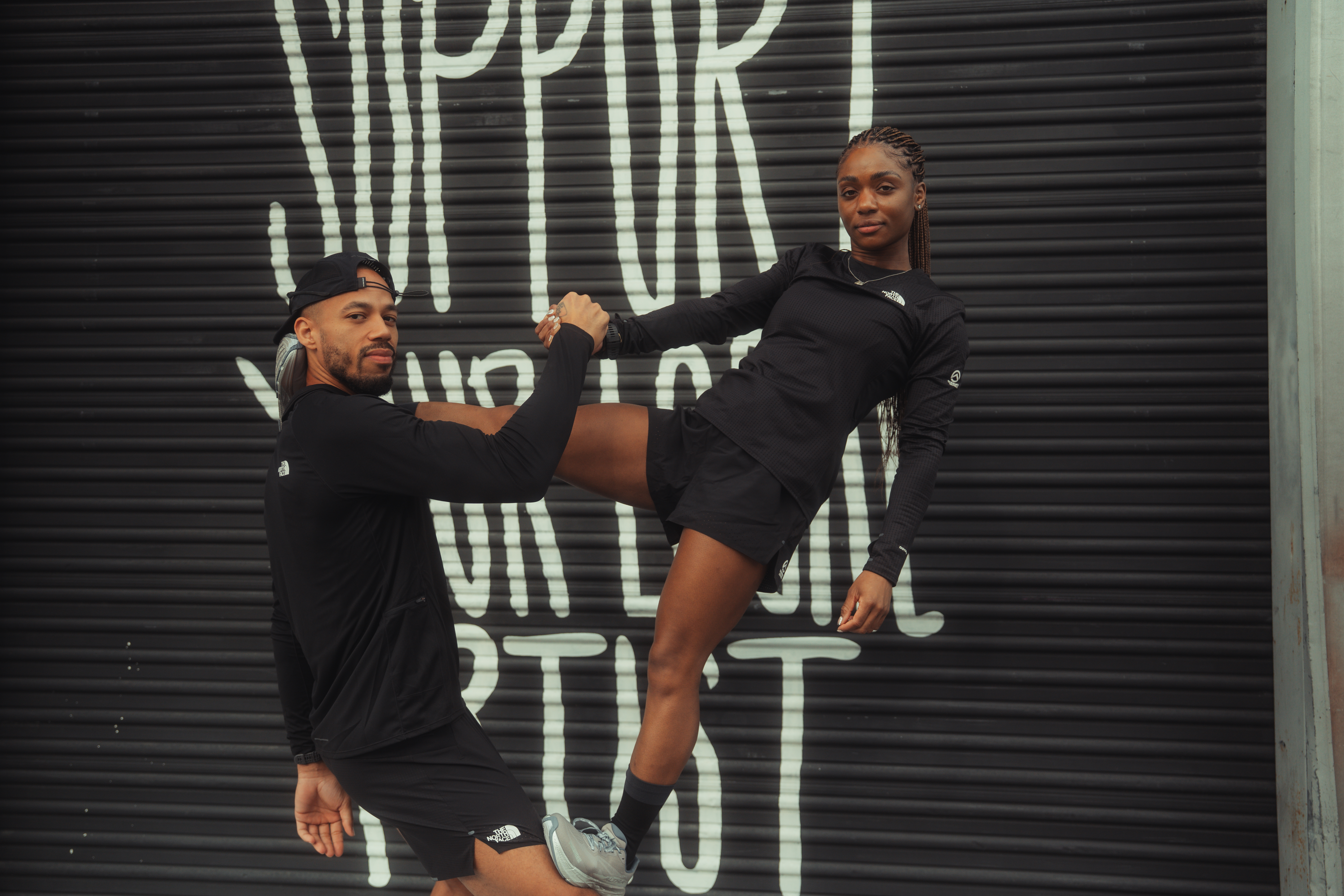 Runners stretching against mural wall